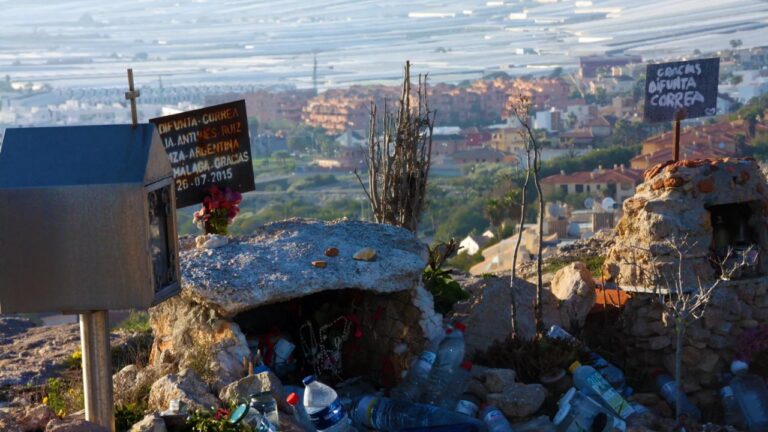 Oratorio de la Difunta Correa en Almerimar, España, con velas y botellas de agua como ofrendas.