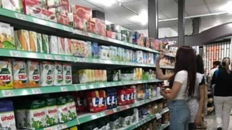 Interior de un supermercado en San Juan con clientes revisando precios en las góndolas.