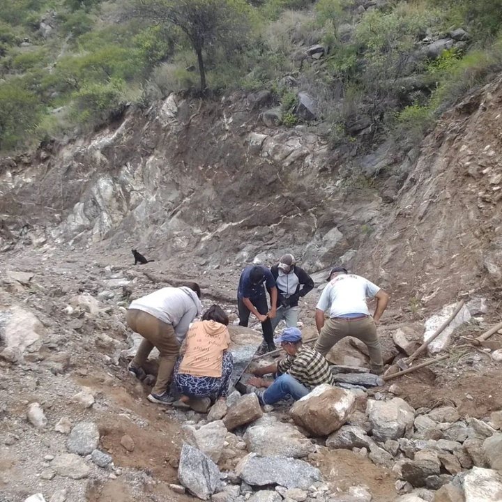 Vecinos trabajando en la reparación de un camino de tierra en una zona serrana de Valle Fértil, San Juan.
